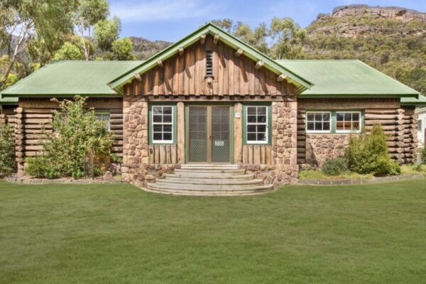 Exterior of the Log Cabin at Breeze Holiday Parks - Halls Gap with Grampians National Park behind