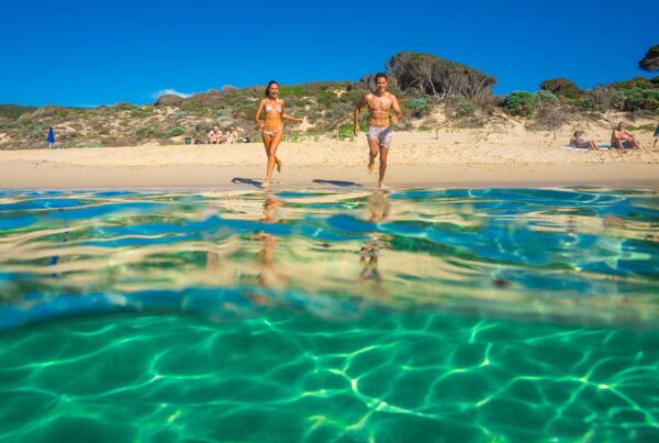 Couple running into the water at the beach in Geographe Bay, Busselton