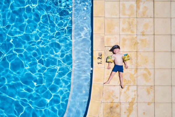 Breeze Holiday Parks - Busselton, child relaxing by the swimming pool
